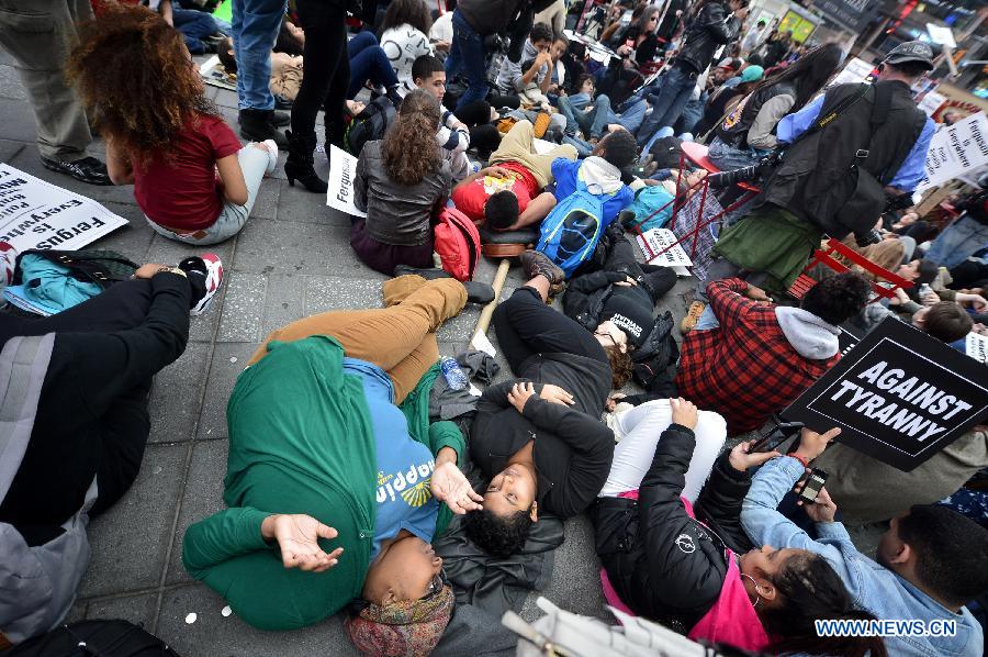 People take part in a protest in New York, the United States, on Dec. 1, 2014. Demonstrations continue over a grand jury's decision last week not to charge police officer Darren Wilson who fatally shot unarmed 18-year-old Michael Brown in Ferguson, Missouri. [Photo/Xinhua] 