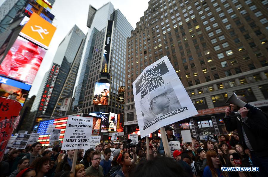 People take part in a protest in New York, the United States, on Dec. 1, 2014. Demonstrations continue over a grand jury's decision last week not to charge police officer Darren Wilson who fatally shot unarmed 18-year-old Michael Brown in Ferguson, Missouri. [Photo/Xinhua]