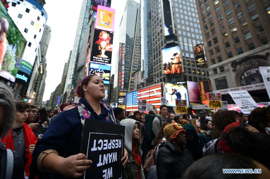 People take part in a protest in New York, the United States, on Dec. 1, 2014. Demonstrations continue over a grand jury's decision last week not to charge police officer Darren Wilson who fatally shot unarmed 18-year-old Michael Brown in Ferguson, Missouri. [Photo/Xinhua]