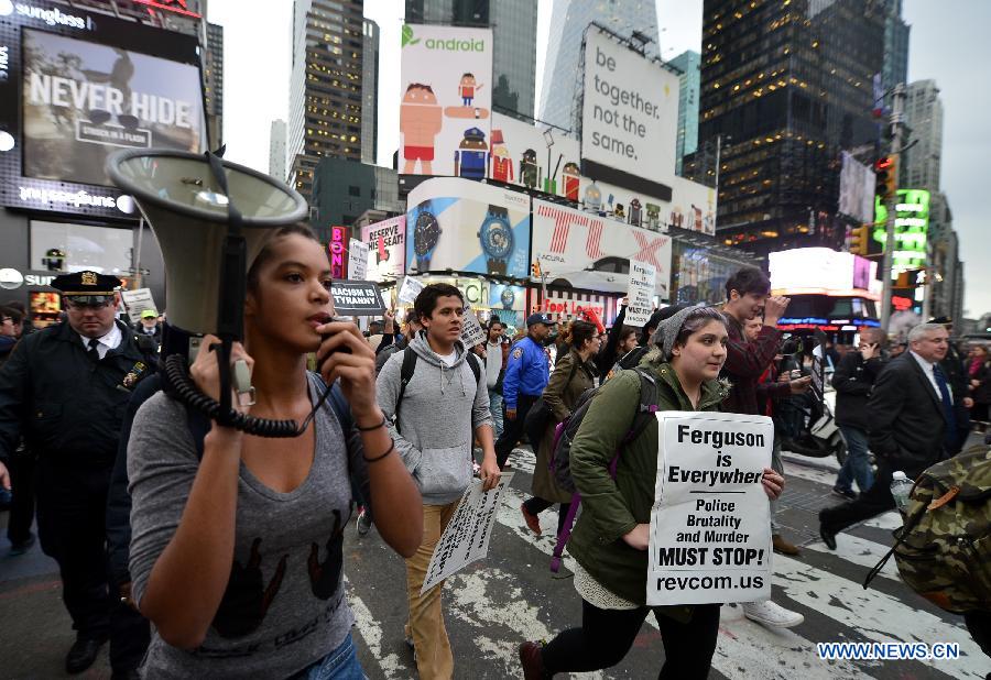 People take part in a protest in New York, the United States, on Dec. 1, 2014. Demonstrations continue over a grand jury's decision last week not to charge police officer Darren Wilson who fatally shot unarmed 18-year-old Michael Brown in Ferguson, Missouri. [Photo/Xinhua]