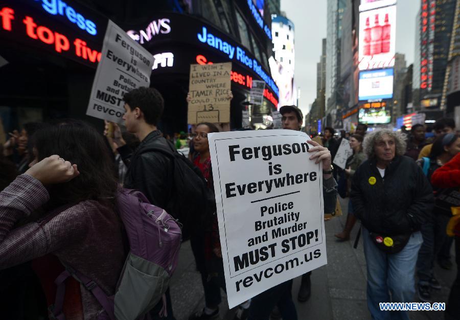 People take part in a protest in New York, the United States, on Dec. 1, 2014. Demonstrations continue over a grand jury's decision last week not to charge police officer Darren Wilson who fatally shot unarmed 18-year-old Michael Brown in Ferguson, Missouri. [Photo/Xinhua]