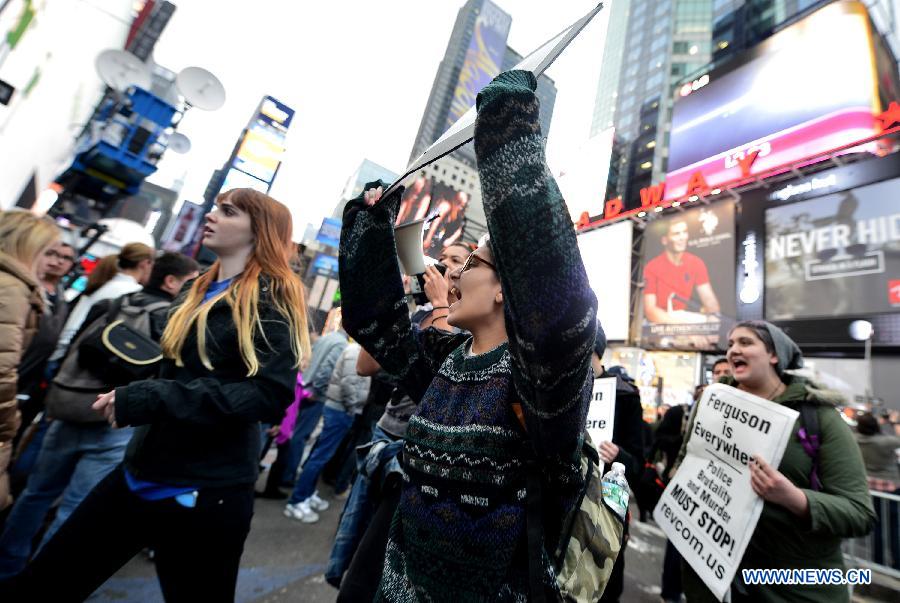 People take part in a protest in New York, the United States, on Dec. 1, 2014. Demonstrations continue over a grand jury's decision last week not to charge police officer Darren Wilson who fatally shot unarmed 18-year-old Michael Brown in Ferguson, Missouri. [Photo/Xinhua]