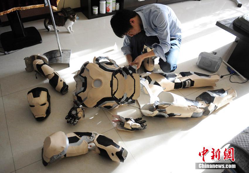 Zu Bingqun fixes the costume of Iron Man. [Photo/Chinanews]