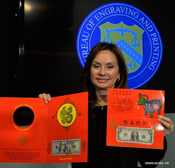U.S. Treasurer Rosie Rios displays the '$100 Dragon-Phoenix Circle of Fortune' lucky money notes during a press conference in Washington D.C., capital of the United States, Dec. 2, 2014. The U.S. Treasury Department on Tuesday unveiled its two latest seasonal additions-- Federal Reserve note and $100 Federal Reserve note to its 'Lucky Money' collections to celebrate the upcoming Chinese Lunar New Year of the Goat in 2015. [Photo/Xinhua/]