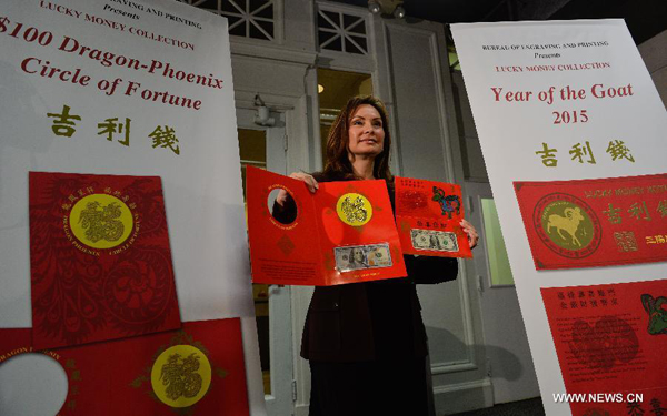 U.S. Treasurer Rosie Rios displays the ' Year of the Goat 2015 and $100 Dragon-Phoenix Circle of Fortune' lucky money notes during a press conference in Washington D.C., capital of the United States, Dec. 2, 2014. The U.S. Treasury Department on Tuesday unveiled its two latest seasonal additions-- Federal Reserve note and $100 Federal Reserve note to its 'Lucky Money' collections to celebrate the upcoming Chinese Lunar New Year of the Goat in 2015. [Photo/Xinhua]