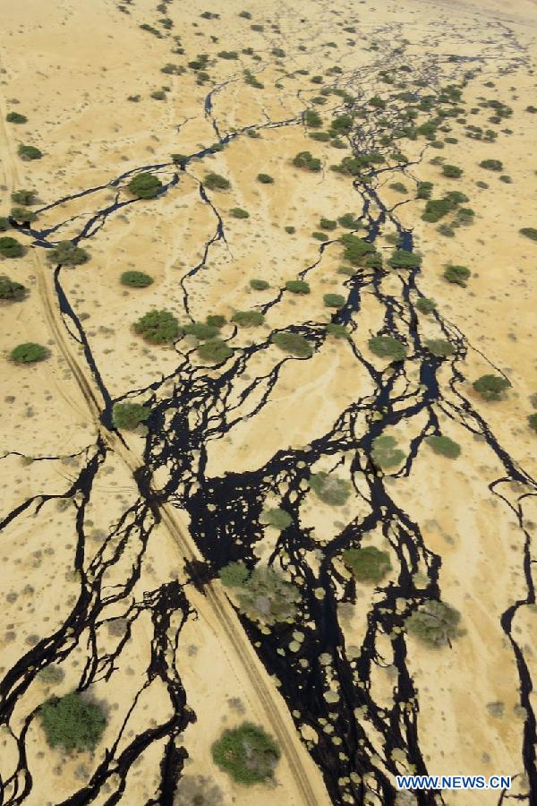 Handout aerial photograph provided by the Israeli Ministry of Environmental Protection shows a large oil spillage caused by an oil pipeline that breached during maintenance work in the Arava desert, southern Israel, on Dec. 4, 2014. An oil spill flooded overnight a desert nature reserve in southern Israel, causing 'one of the worst' ecological disasters in Israel, officials and local media said Thursday. [Photo/Xinhua]