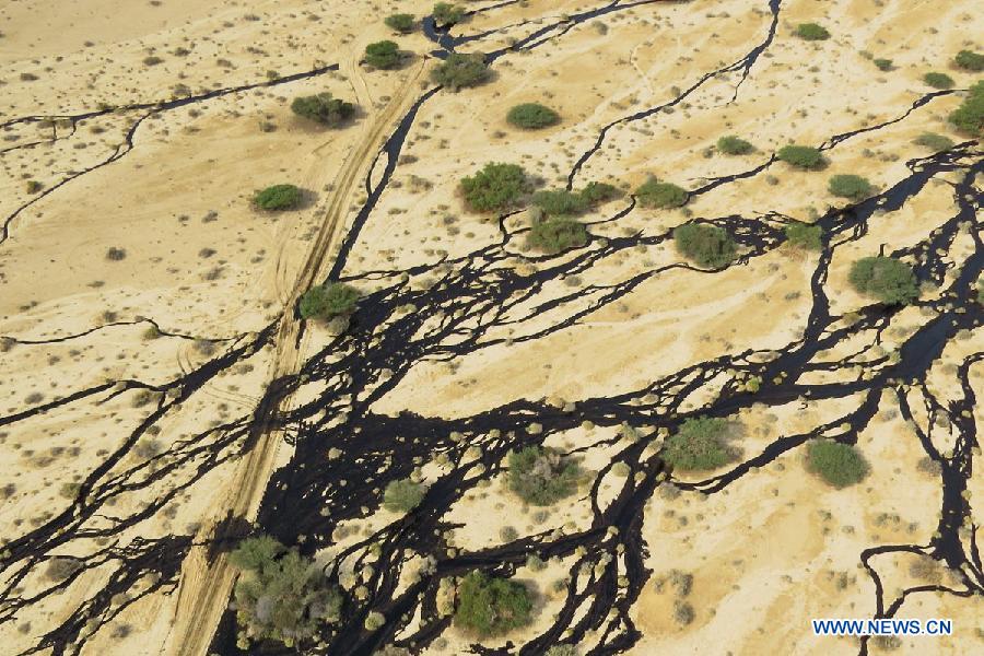 Handout aerial photograph provided by the Israeli Ministry of Environmental Protection shows a large oil spillage caused by an oil pipeline that breached during maintenance work in the Arava desert, southern Israel, on Dec. 4, 2014. An oil spill flooded overnight a desert nature reserve in southern Israel, causing 'one of the worst' ecological disasters in Israel, officials and local media said Thursday. [Photo/Xinhua]