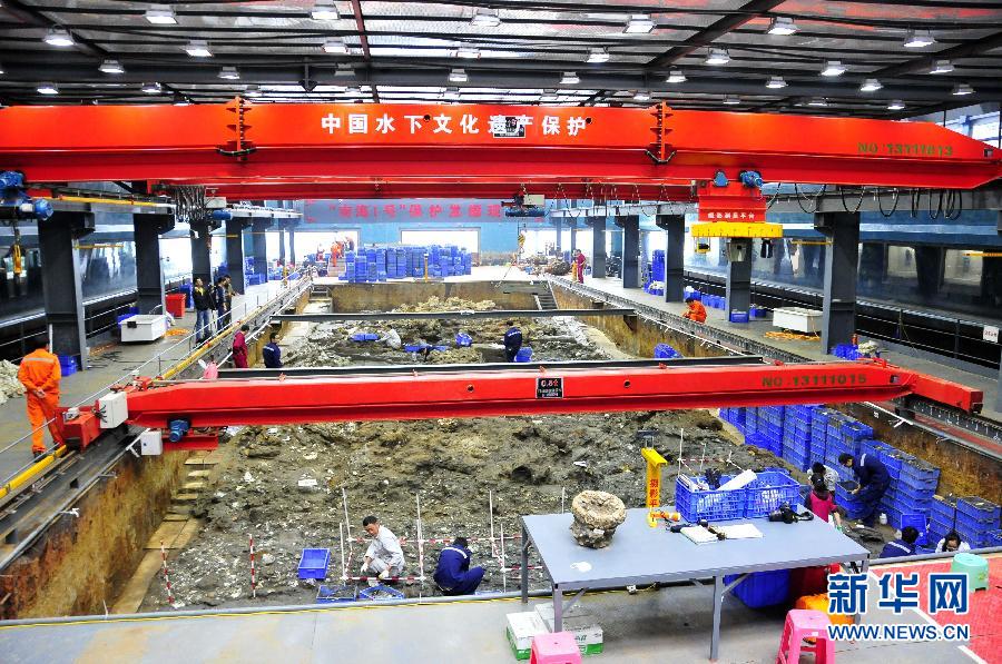 Archaeologists sift through the interiors of the wrecked ship belonging to the Song Dynasty 'Nanhai Number One' on Dec 2, 2014. [Photo/Xinhua]