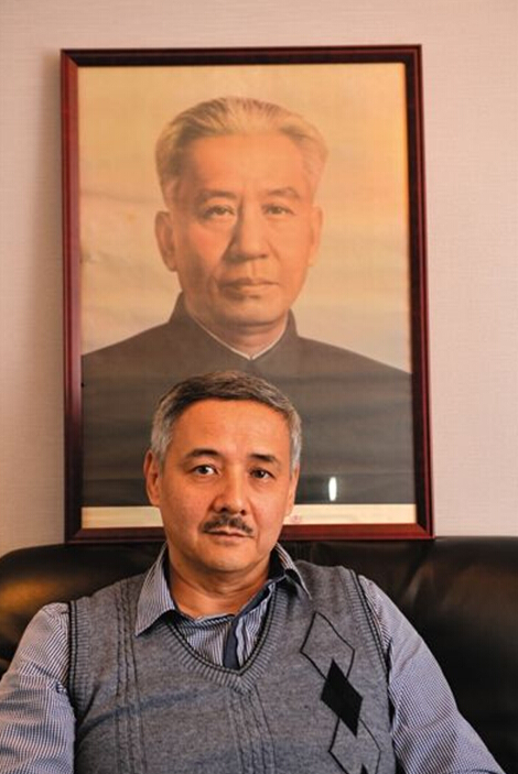 Alyosha sits in his office in Guangzhou. A picture of his grandfather Liu Shaoqi is hung on the wall. [Photo/The Beijing News] 