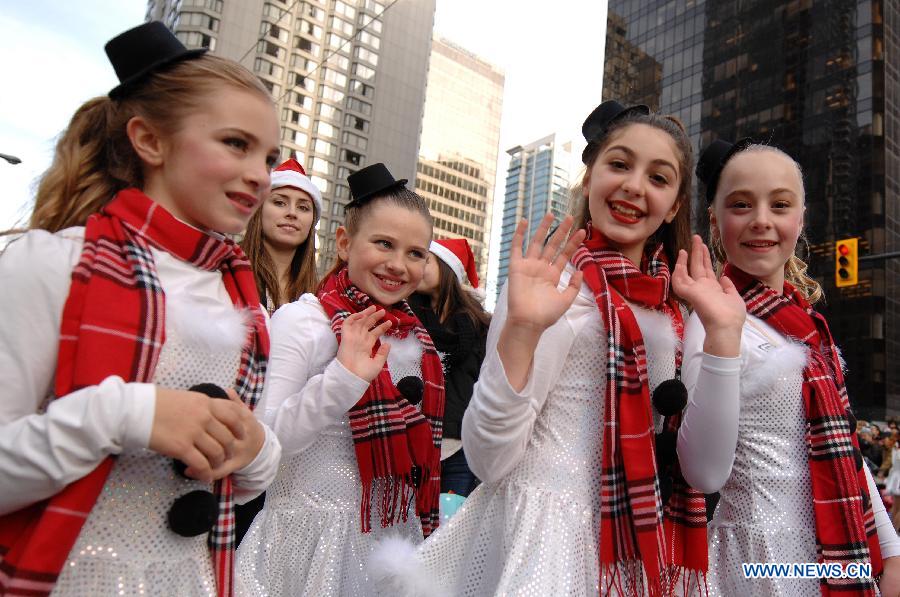 Members of the Shift Dance Academy take part in the Santa Claus Parade in Vancouver, Canada, Dec. 7, 2014. The 11th annual parade attracted more than 300,000 spectators and featured 3,800 participants and 300 volunteers as a pre-Christmas tour through the streets of Vancouver. [Photo/Xinhua]