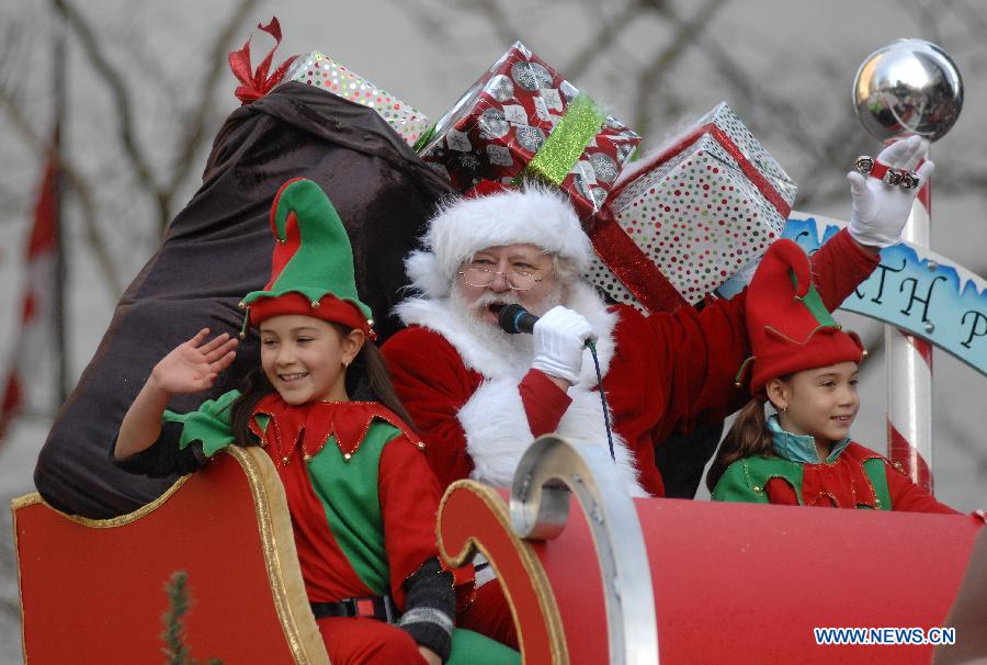 A man dressed as Santa waves his hands during the Santa Claus Parade in Vancouver, Canada, Dec. 7, 2014. The 11th annual parade attracted more than 300,000 spectators and featured 3,800 participants and 300 volunteers as a pre-Christmas tour through the streets of Vancouver. [Photo/Xinhua]
