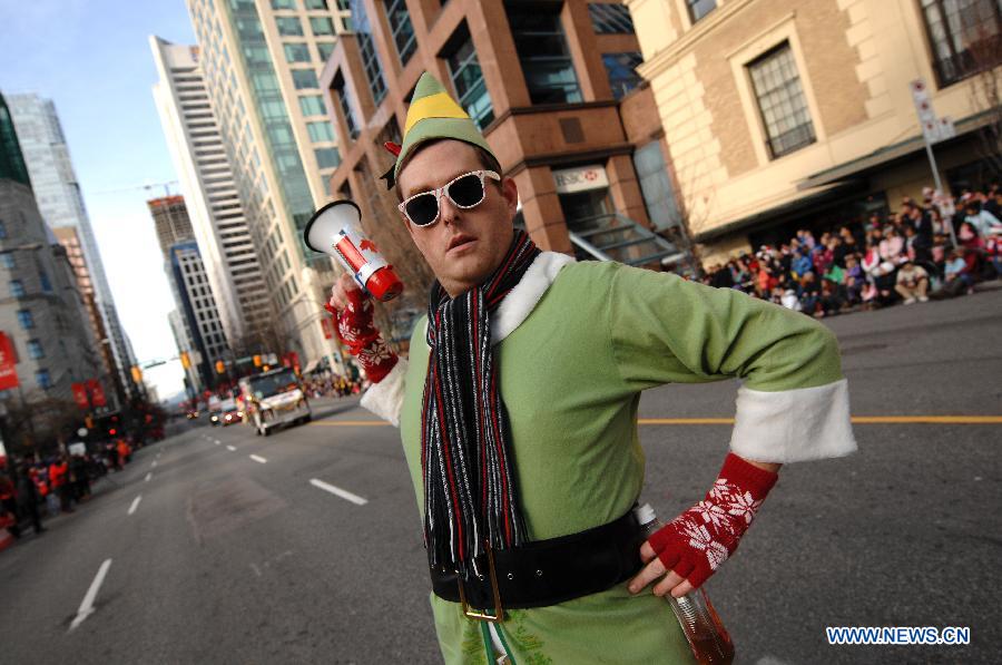 A man dressed as an elf poses during the Santa Claus Parade in Vancouver, Canada, Dec. 7, 2014. The 11th annual parade attracted more than 300,000 spectators and featured 3,800 participants and 300 volunteers as a pre-Christmas tour through the streets of Vancouver. [Photo/Xinhua]
