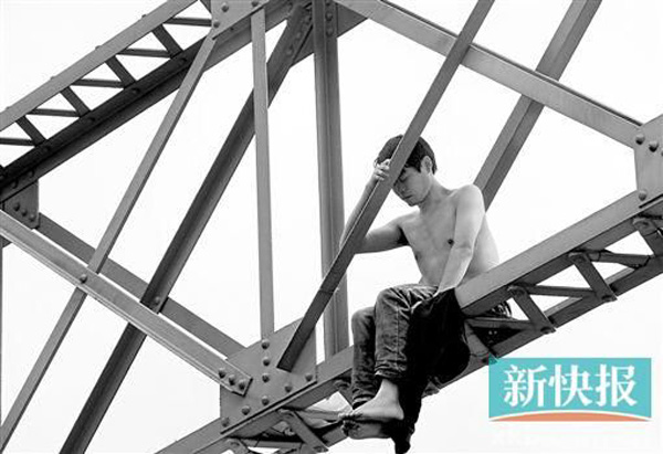 A man sits on top of the Haizhu Bridge in Guangzhou, South China’s Guangdong province, on Monday. [Photo/xkb.com.cn]