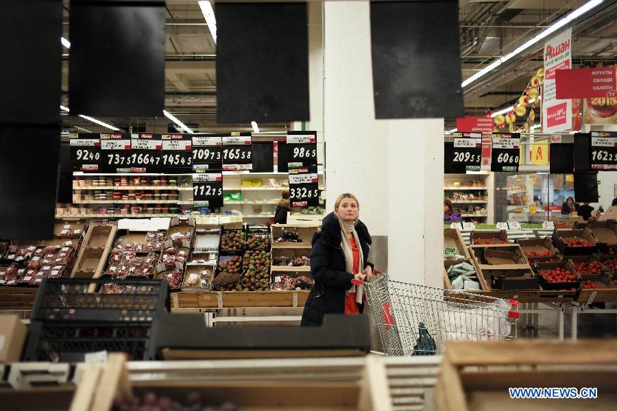 A woman choose fruits at a supermarket in Moscow, Russia, Dec. 17, 2014. Russian Prime Minister Dmitry Medvedev on Wednesday warned citizens and companies of attempting to make profit in the current unstable financial situation, calling the ongoing events at the currency market a 'game of emotions.' [Photo/Xinhua] 