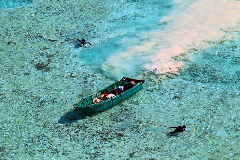 Two villagers fish at a reef in the Yongle Islands, Hainan province, on May 25, 2013. [Photo/Asiannews]