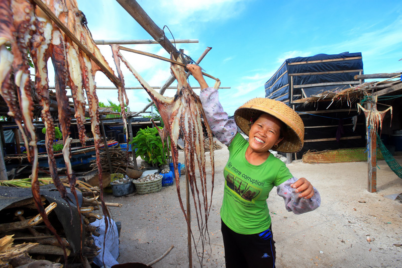 A villager in Zhaoshu Island of Xisha dries octopus. The Xisha Islands are home to over 400 kinds of fishes. [Photo/Asiannews]