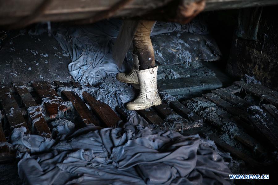 An Egyptian worker carries leather at a leather tanning factory in Cairo, Egypt, on Dec. 20, 2014. The annual revenue of Egyptian exported leather products reaches hundreds millions of U.S. dollars. [Photo/Xinhua] 