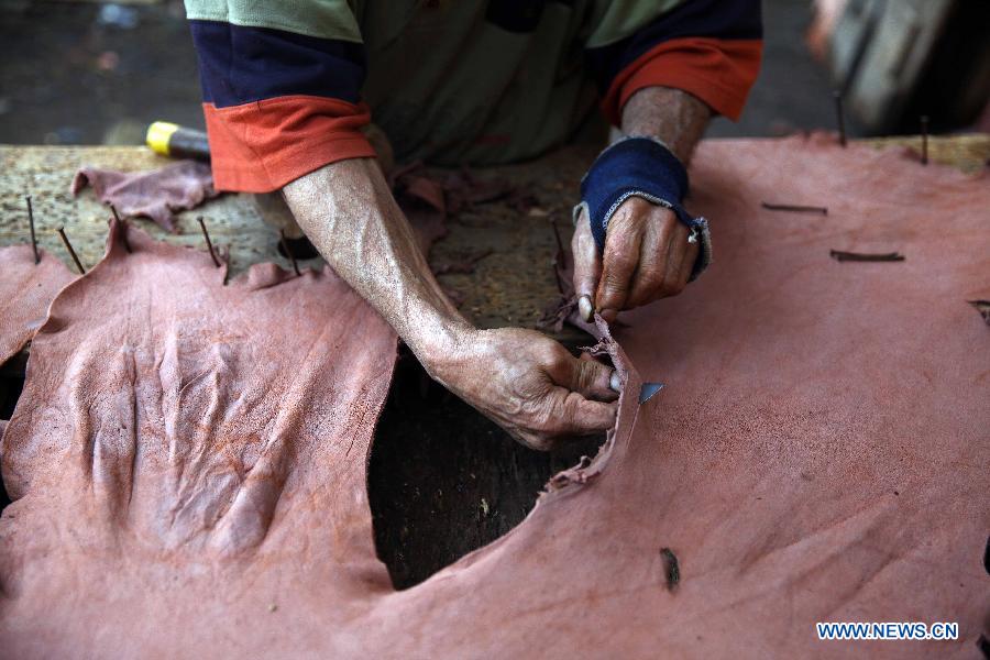 Hussin Mohamed, 74, works on preparing animal skins in a leather tanning factory in Cairo, Egypt,on Dec. 20, 2014. The annual revenue of Egyptian exported leather products reaches hundreds millions of U.S. dollars. [Photo/Xinhua] 