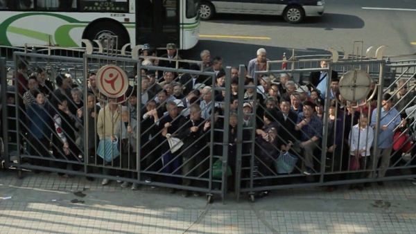 Seniors crowd at the front gate of a supermarket before opening time in Shanghai, on Dec 18, 2014. [Photo/163.com]