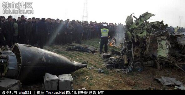 Police cordon off the crash site on Monday, December 22, 2014 as people gather near the body of a pilot killed in the accident.[Photo/Tiexue.net] 