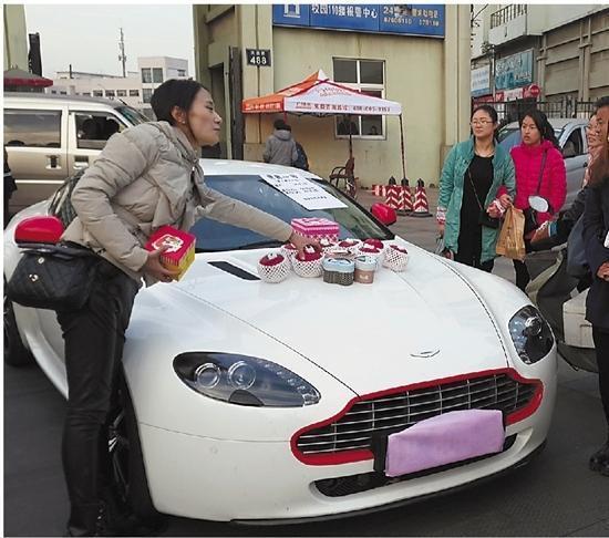 Zhang sells apples arranged on an Aston Martin, in Ningbo, East China's Zhejiang province. [Photo/Weibo.com]