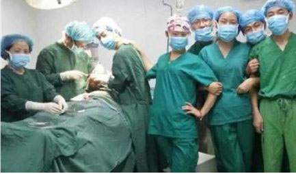 Doctors take group selfies next to a patient inside an operating room in Xi'an Fengcheng Hospital on Aug 15, 2014. [Photo/Sina Weibo] 
