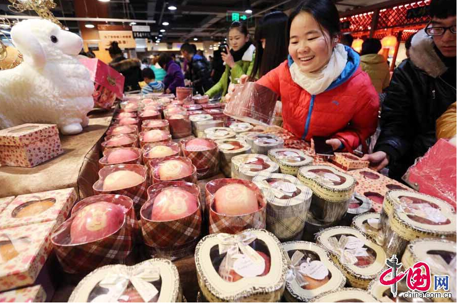 Citizens buy Christmas 'blessing apples' at a supermarket in Xuchang, Henan Province on Dec. 20, 2014. The staff at the supermarket gift-wrapped the apples and carved artistic characters on them such as 'I love you,' '999 roses,' and 'silent night.' [China.org.cn]