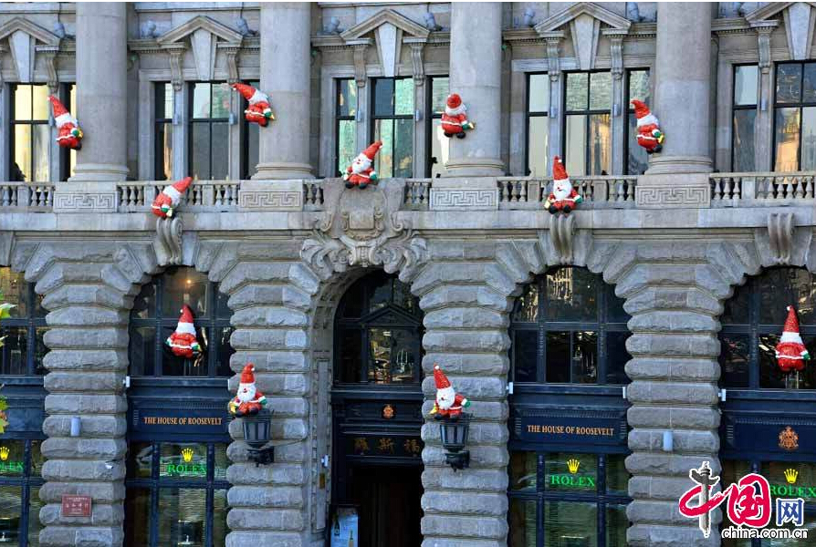 As Christmas approaches, dozens of 'Santa Claus' figures were placed as decorations outside a building on the Bund in Shanghai on Dec. 22, 2014. [China.org.cn] 