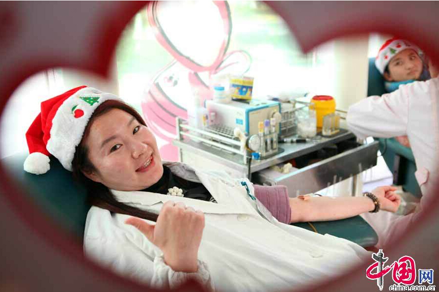 Dozens of nurses and medical workers from a community health service center dressed in Christmas and Santa costumes donated blood in this small room in Shanghai on Dec, 23, 2014. [China.org.cn]