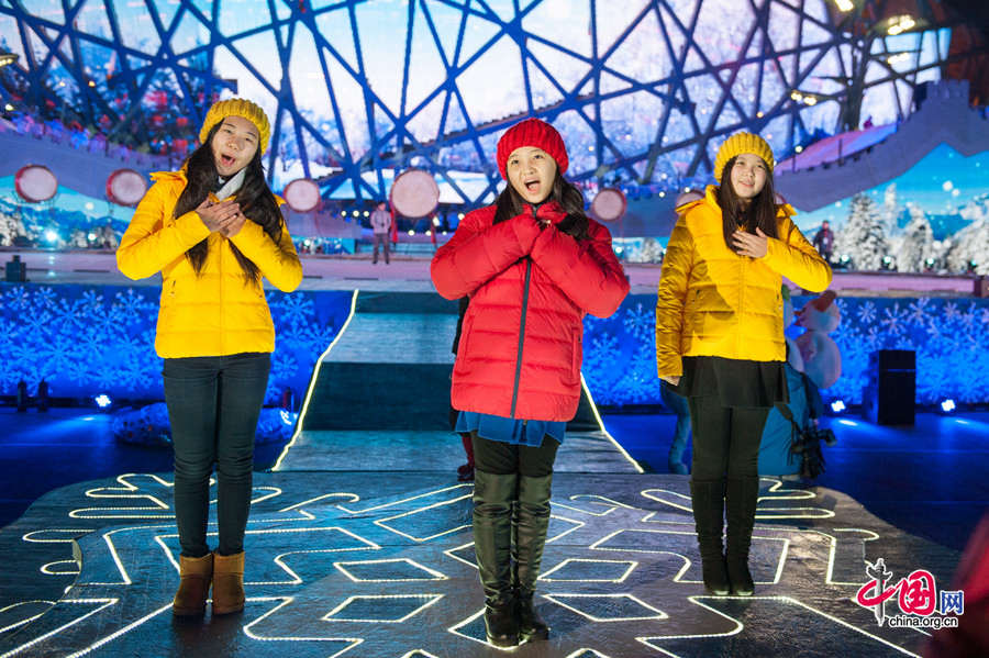 Lin Miaoke (M) and her friends sing at the rehearsal of Countdown to 2015, the New Year celebration, on Dec. 30, one day ahead of the actual ceremony. The New Year celebration &apos;Countdown to 2015&apos; holds its last rehearsal at Beijing&apos;s Olympic Park, where the national symbols of the Bird&apos;s Nest stadium and the Water Cube National Aquatics Center are located, on Tuesday, Dec. 30, 2014. The ceremony also features the Chinese capital&apos;s bidding for the 2022 Winter Olympics. [Photo by Chen Boyuan / China.org.cn]