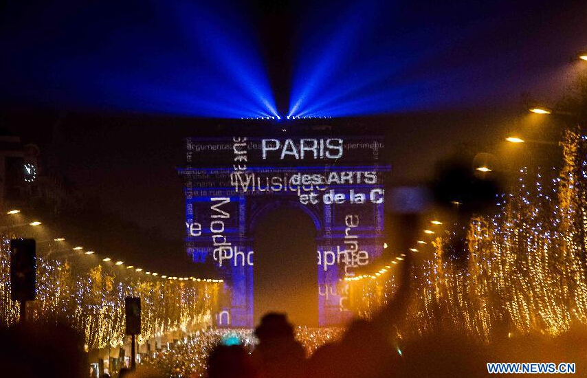 People watch the light show fireworks over the Arc de Triomphe as they celebrate the New Year's Eve on the Champs Elysees avenue in Paris, France, Dec. 31, 2014. (Xinhua/Chen Xiaowei) 