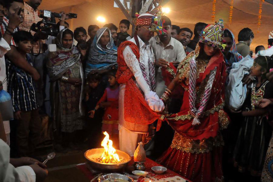 A Pakistani Hindu couple performs a Hindu ritual during a group wedding ceremony in southern Pakistani port city of Karachi, on Jan. 2, 2015. A total of 50 couples attended a group wedding organized by the Pakistan Hindu Council. [Photo/Xinhua] 