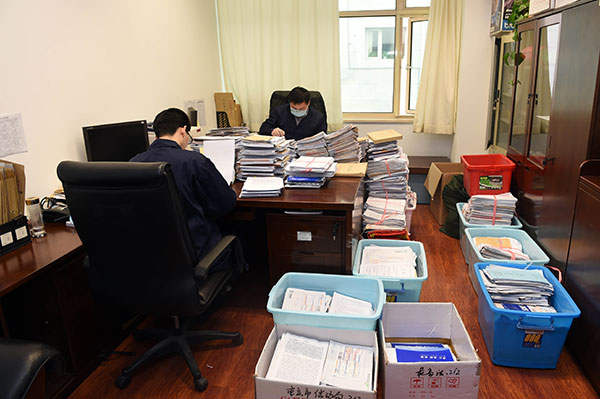 Two officials read the letters that have been sorted and opened. [Photo/ CCDI website]