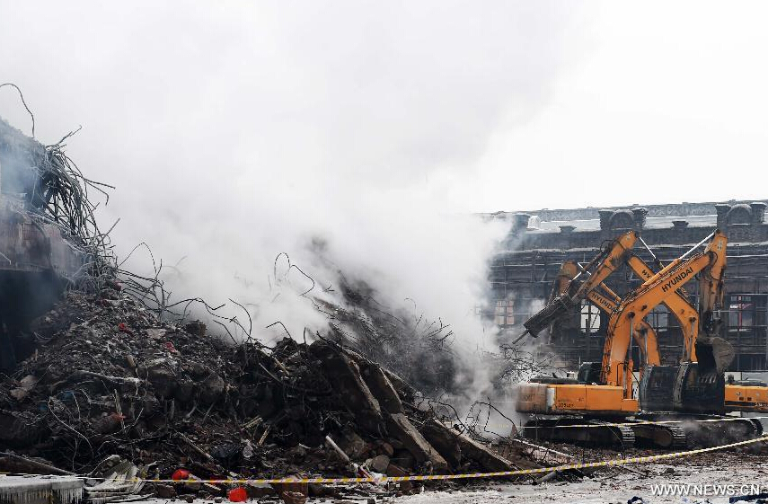 Heavy machinery clear the debris of a burnt warehouse at the Beifangnanxun ceramics market in Daowai District, Harbin, capital of northeast China's Heilongjiang Province, Jan. 4, 2014.[Photo/Xinhua]