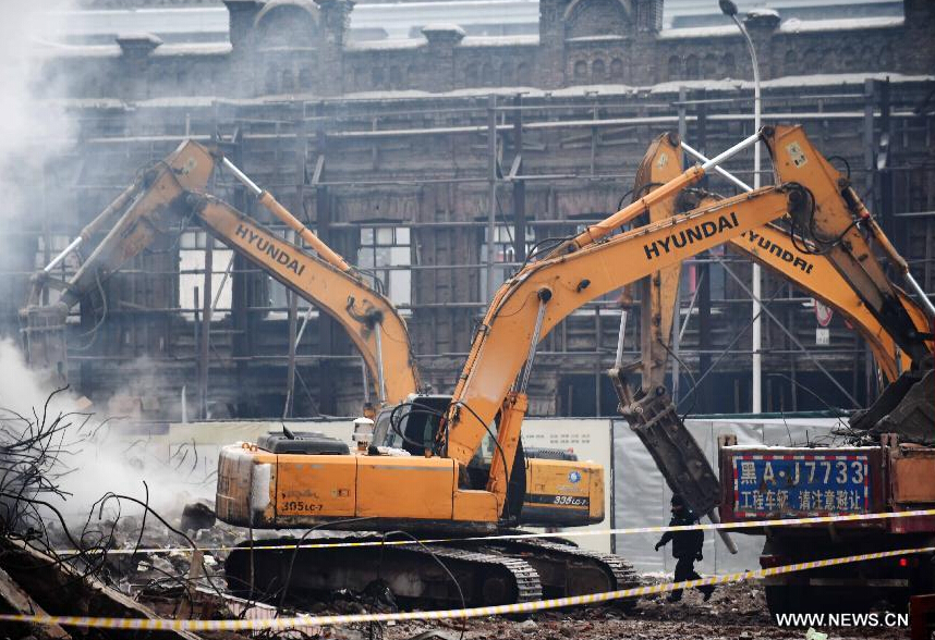 Heavy machinery clear the debris of a burnt warehouse at the Beifangnanxun ceramics market in Daowai District, Harbin, capital of northeast China's Heilongjiang Province, Jan. 4, 2014.[Photo/Xinhua] 
