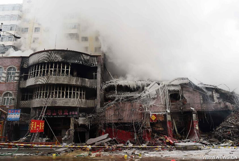 Smokes rise from a burnt warehouse at the Beifangnanxun ceramics market in Daowai District, Harbin, capital of northeast China's Heilongjiang Province, Jan. 4, 2014.