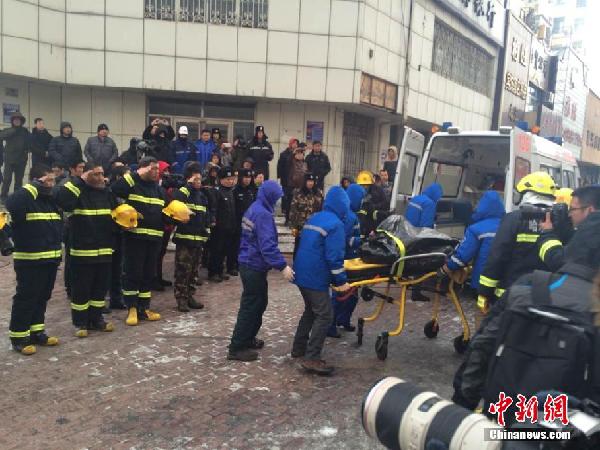 The bodies of two firefighters were found at the site of a warehouse collapse caused by fire burning in Harbin city of northeast China's Heilongjiang Province on Saturday, January 3, 2015. Five firefighters were killed and at least 13 others were injured in the collapse that occurred on January 2, 2015. [Photo: Chinanews.com]