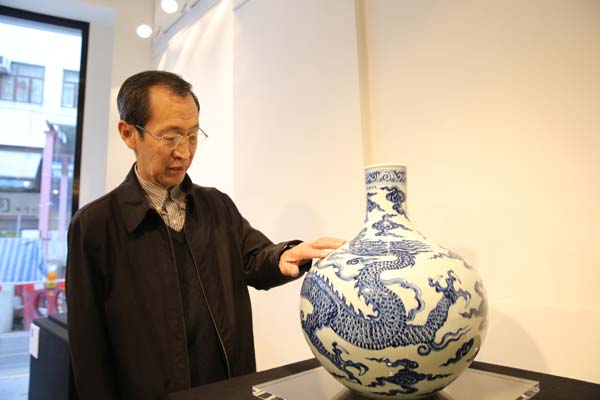 Sun Hongqi introduces a blue-and-white vase with a round belly and dragon motifs of Xuande period. [Photo provided to China Daily]