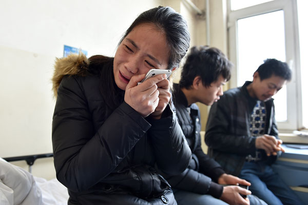 Wang Qian, daughter of Zhou Xiuyun, a 47-year-old female worker who was beaten to death, cries while looking at a photo of her mother. Zhou was one of the 10 migrant workers who were trying to enter a construction site in Taiyuan on Dec 13 to demand their salaries and argued with guards. [Photo/Xinhua]