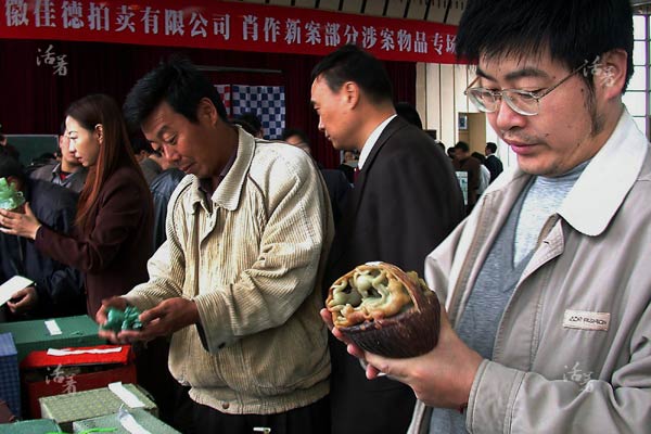 Participants look at jade articles showcased at an auction of corrupt officials' lootin Hefei city, capital of Anhui province. Jade articles from Bengbu constitute a lion share of the loot. [Photo/qq.com]