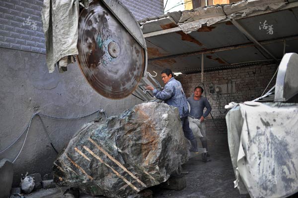 Loud noises can be heard as two men are cutting a big piece of jade at their workshop in Xingfu village in Bengbu city, east China's Anhui province. [Photo/qq.com]