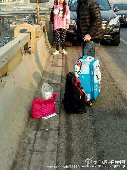 The photo taken on January 12, 2015, shows the luggage and belongings left on the Guomao Bridge in Beijing's Chaoyang District. A woman died after jumping off the bridge on Monday morning. [Photo: weibo.com] 
