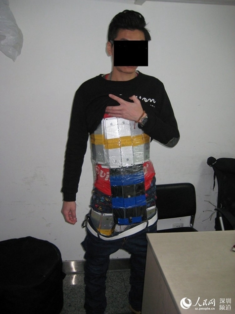 A Hong Kong smuggler hides 94 iPhones under his clothes in order to get the products into the Chinese mainland on Jan. 11, 2015. The male passenger caught the attention of customs staff for his stiff and slow movements. [Photo/people.cn]