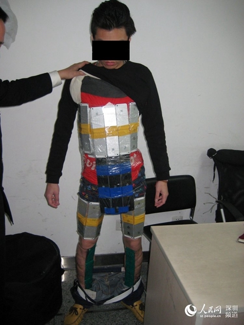 A male Hong Kong resident is found with 94 iPhones wrapped around himself in order to smuggle the products into the Chinese mainland on Jan. 11, 2015. Apple products are often reported to be priced higher in the mainland than in Hong Kong, which leads to many smuggling cases from Hong Kong to the mainland. [Photo: people.cn] 
