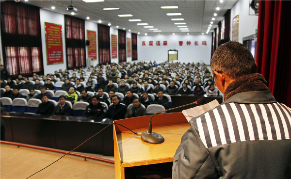 An inmate shares his experience with officials of the local power supply company in Anyang, Henan Province, on Jan 1, 2013. [Photo by Li Gang/Asianewsphoto] 