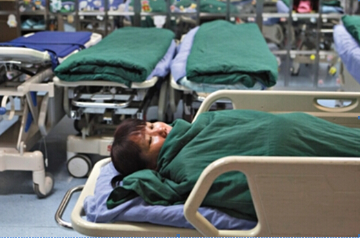 The children's mother lies on a hospital bed before the operation. [Photo/Beijing News]