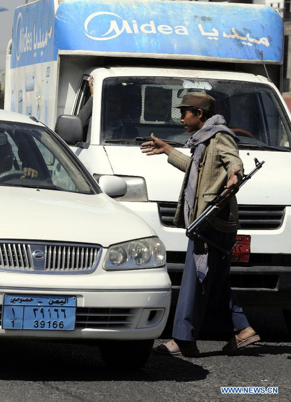 A Houthi fighter checks cars on a road leading to the house of President Abd-Rabbu Mansour Hadi in Sanaa, Yemen, on Jan. 21, 2015. Tensions mounted in Yemen's capital of Sanaa on Wednesday as negotiations between the government and Houthi group are underway to put an end to the political crisis. [Photo/Xinhua]