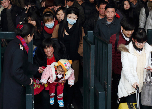 Passengers file through the ticket gates at Beijing Railway Station on Thursday. Millions of people have embarked on their trips home as Spring Festival approaches. [Photo/China Daily]