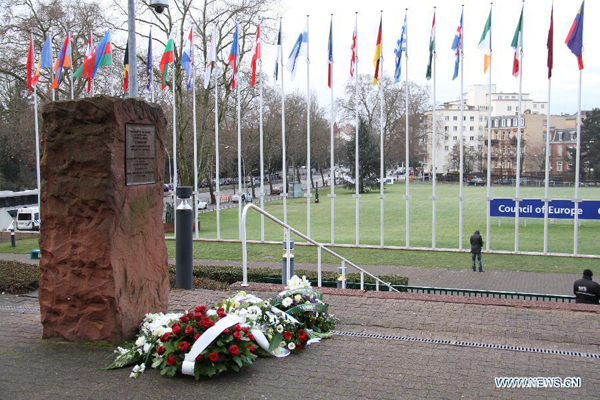 Flowers are laid in front of a commemorative stone to pay tribute to Holocaust victims at the Council of Europe in Strasbourg, France, Jan. 27, 2015. Participants of the Parliamentary Assembly of the Council of Europe attended a commemoration of the 70th anniversary of the liberation of the Nazi German concentration and extermination camp in Auschwitz-Birkenau on Jan. 27, the International Holocaust Remembrance Day. [Photo/Xinhua]