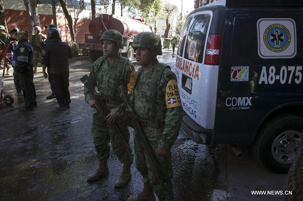 Security forces stand guard at the site where a tanker truck that was supplying gas in front of a hospital exploded, in Mexico City, capital of Mexico, on Jan. 29, 2015. [Photo/Xinhua]